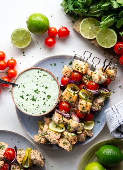 Marinated in a fresh cilantro lime sauce and grilled alongside red onion, cherry tomatoes, and served with a cilantro lime crema, these cilantro lime grilled salmon kabobs are a quick dinner to throw on the grill for any occasion.