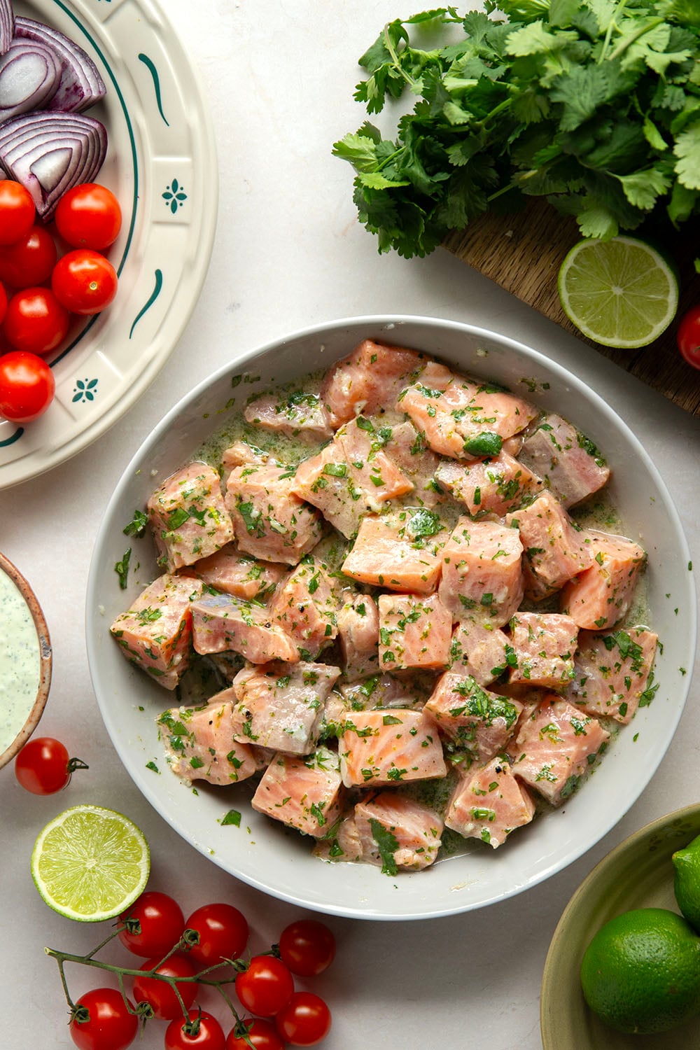 Marinated in a fresh cilantro lime sauce and grilled alongside red onion, cherry tomatoes, and served with a cilantro lime crema, these cilantro lime grilled salmon kabobs are a quick dinner to throw on the grill for any occasion.