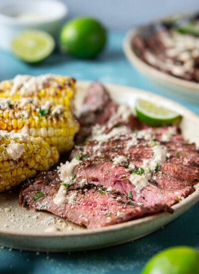 Spice-rubbed grilled flank steak and corn is an easy summer dish that pairs very well with a creamy chili lime sauce drizzled on top.