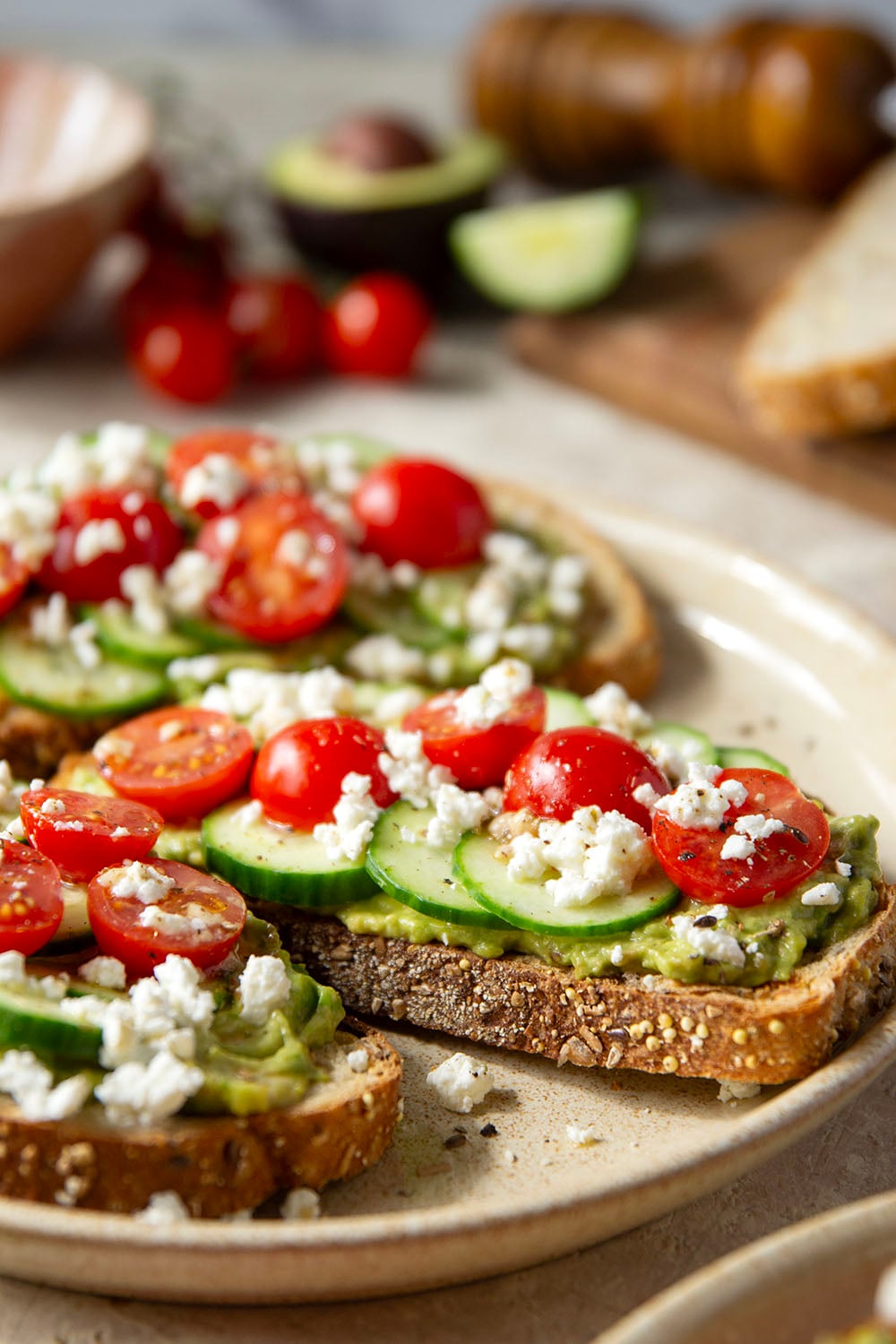 This Greek avocado toast is quick and easy enough for any kind of breakfast occasion! Pile toasted bread slices with silky mashed avocado, crisp cucumber slices, lots of fresh cherry tomatoes, and feta.