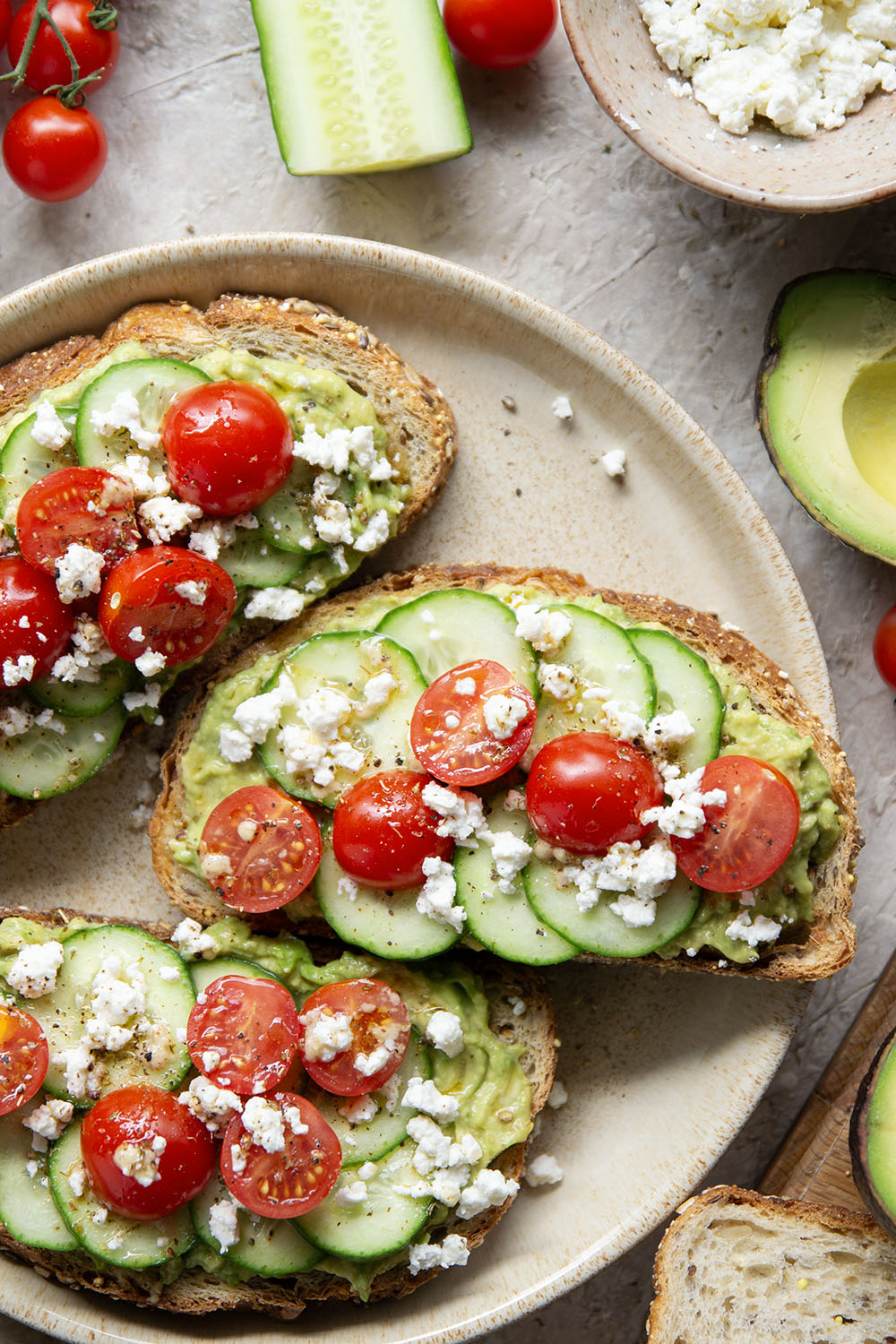 This Greek avocado toast is quick and easy enough for any kind of breakfast occasion! Pile toasted bread slices with silky mashed avocado, crisp cucumber slices, lots of fresh cherry tomatoes, and feta.