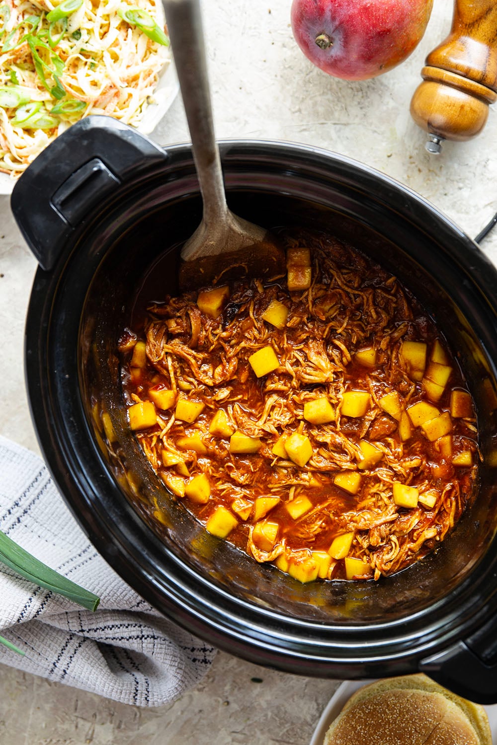 Slow cooked until perfectly fall-apart tender in lots of sweet mango and a homemade sauce, this pulled mango BBQ chicken makes the best summer sandwich with fresh slaw on top.