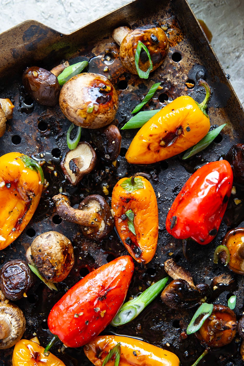 A mix of mushrooms and mini sweet peppers are marinated for hours in a flavorful soy marinade, grilled until tender and smoky, and topped with lots of green onions for an easy summer veggie side dish.