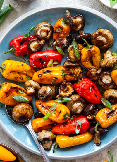 A mix of mushrooms and mini sweet peppers are marinated for hours in a flavorful soy marinade, grilled until tender and smoky, and topped with lots of green onions for an easy summer veggie side dish.