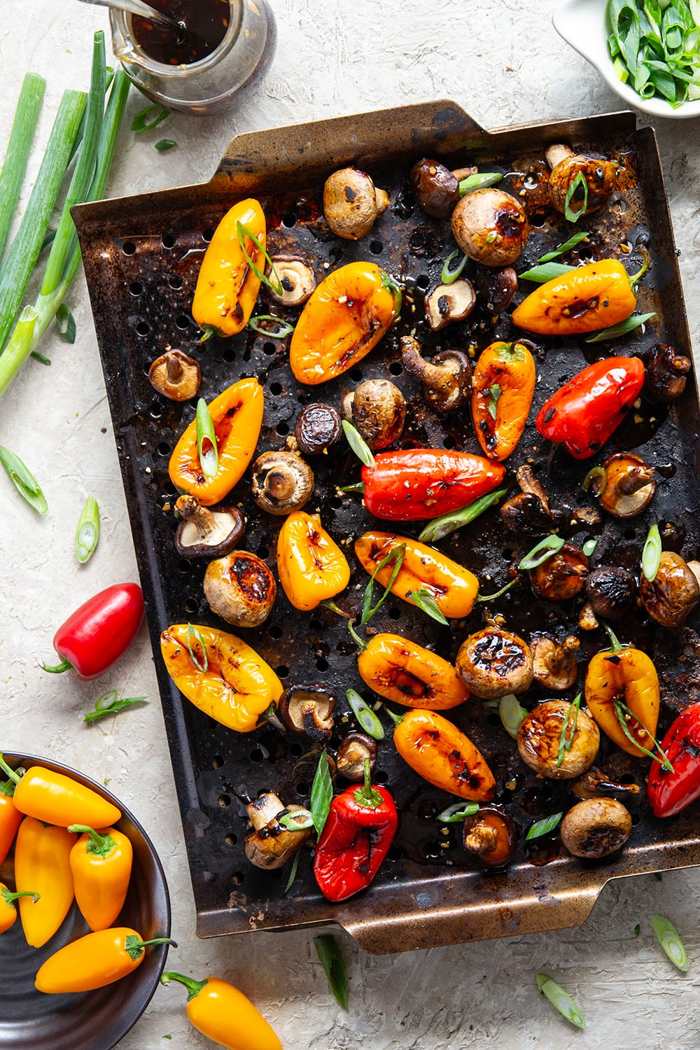 A mix of mushrooms and mini sweet peppers are marinated for hours in a flavorful soy marinade, grilled until tender and smoky, and topped with lots of green onions for an easy summer veggie side dish.