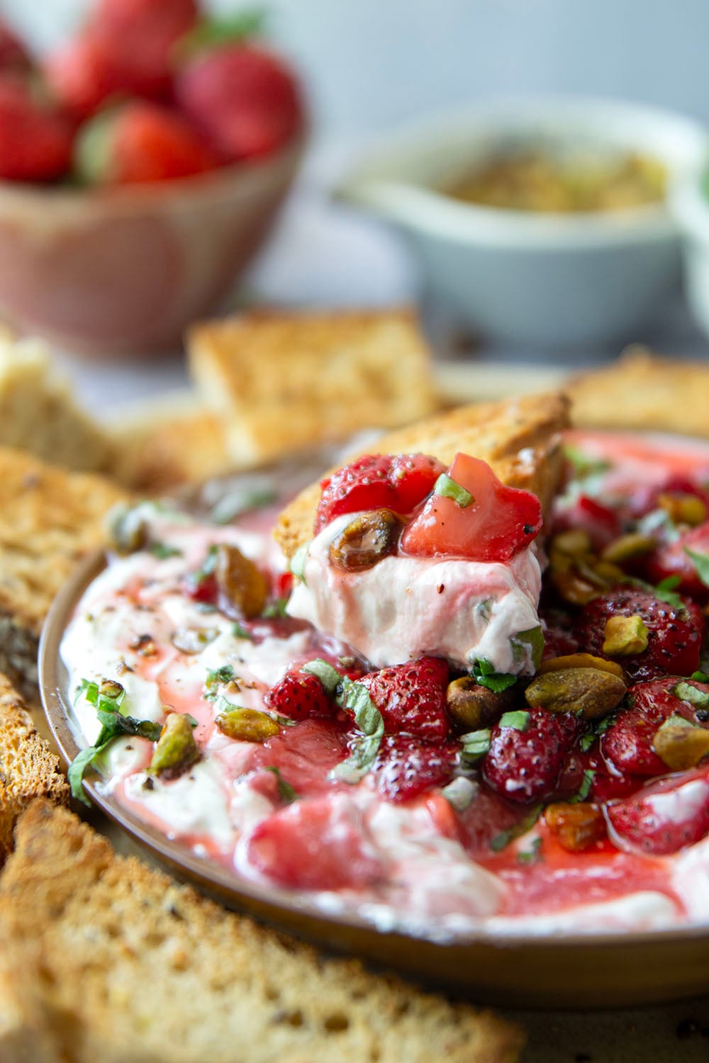 Silky whipped goat cheese is topped with juicy honey roasted strawberries and incredible served with crostini for dipping.