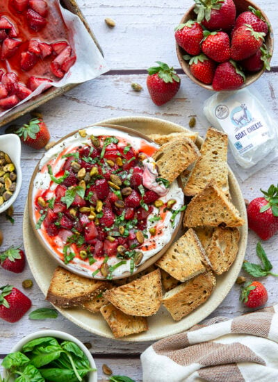Silky whipped goat cheese is topped with juicy honey roasted strawberries and incredible served with crostini for dipping.