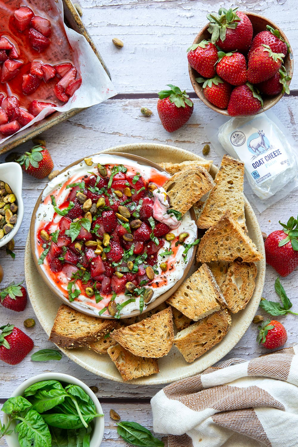 Silky whipped goat cheese is topped with juicy honey roasted strawberries and incredible served with crostini for dipping.