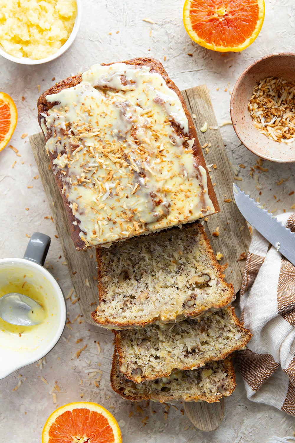 This tropical banana bread features a perfectly soft and dense texture and is packed with flaked coconut, lots of pineapple, and topped with a sweet citrus glaze.