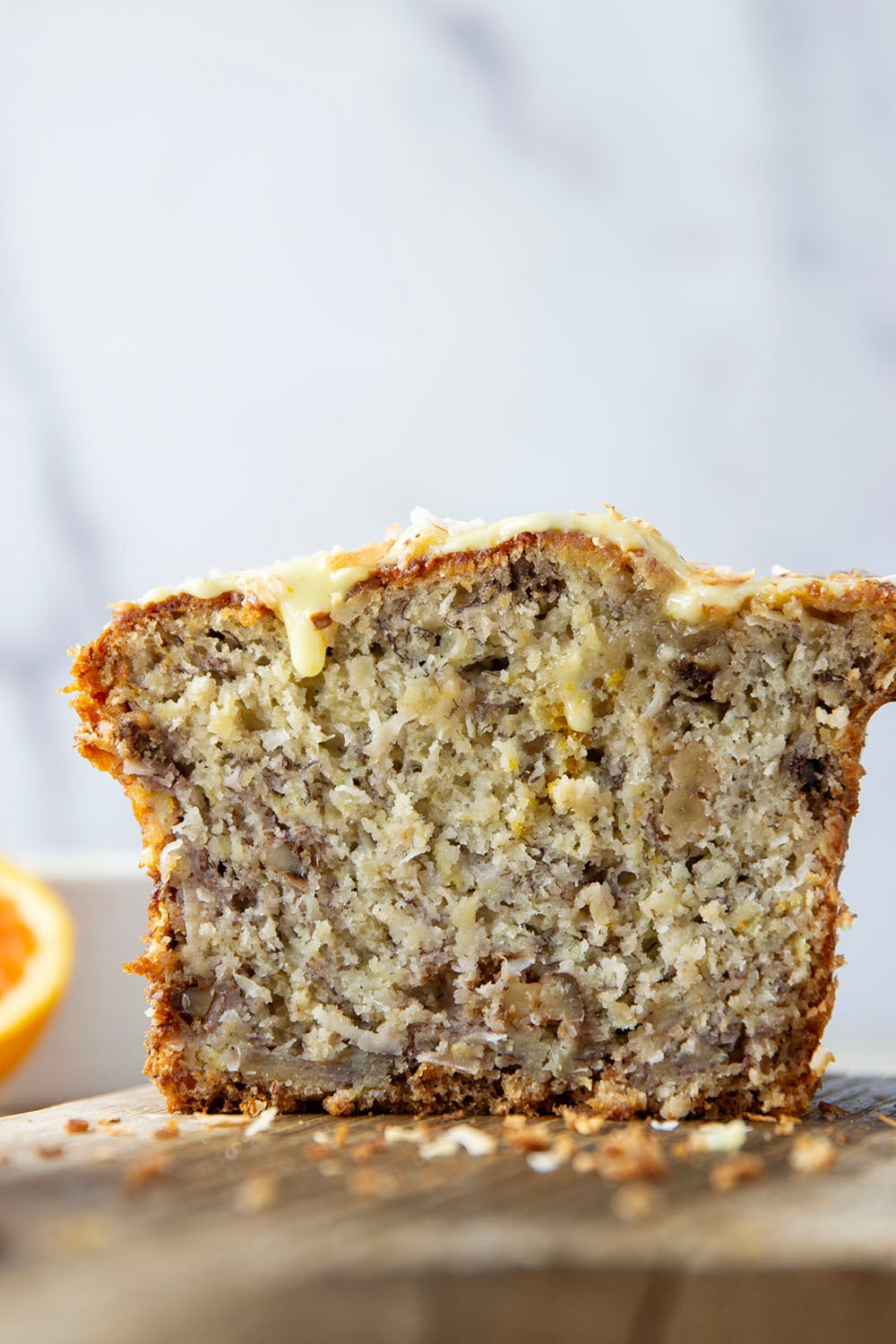 This tropical banana bread features a perfectly soft and dense texture and is packed with flaked coconut, lots of pineapple, and topped with a sweet citrus glaze.