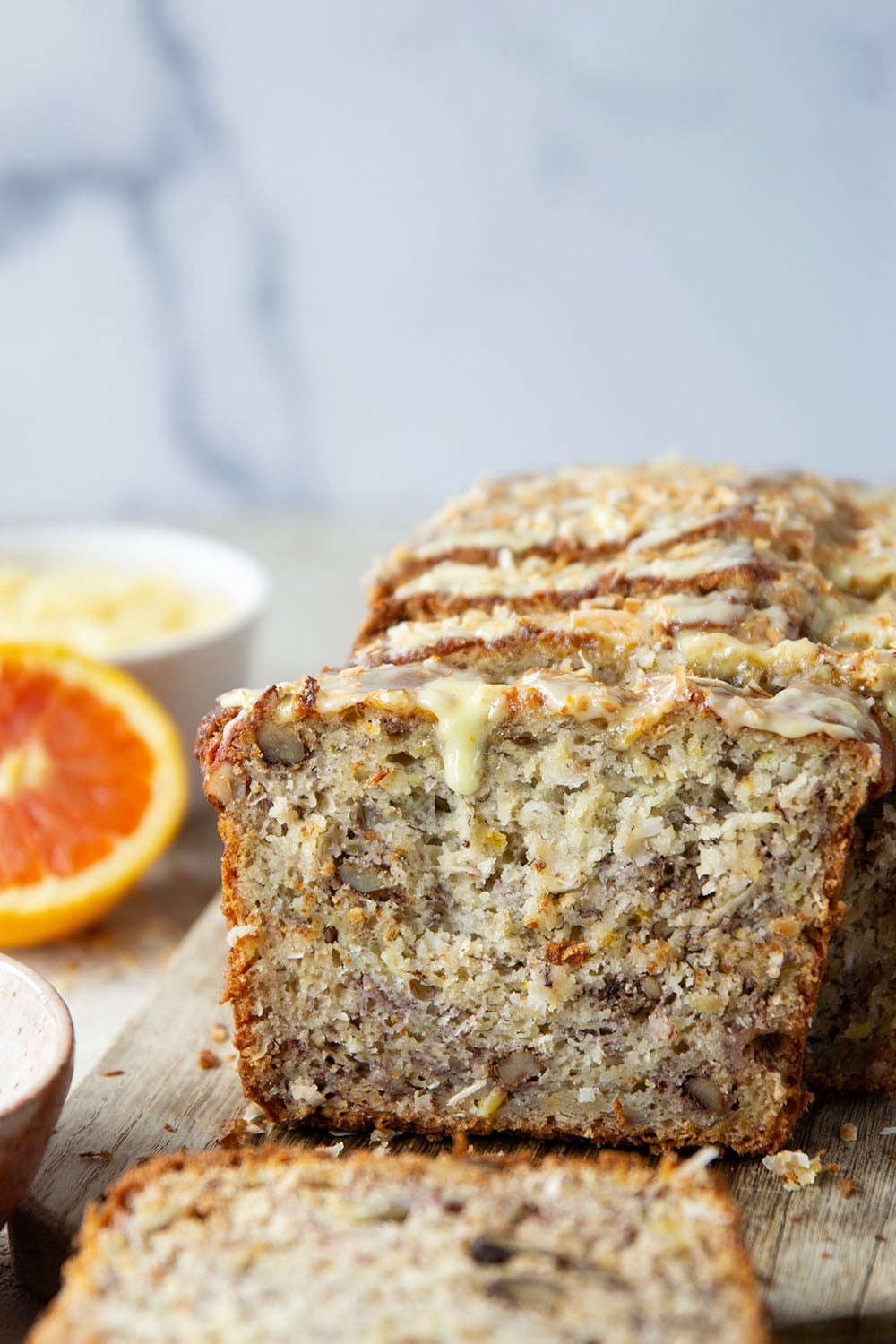This tropical banana bread features a perfectly soft and dense texture and is packed with flaked coconut, lots of pineapple, and topped with a sweet citrus glaze.