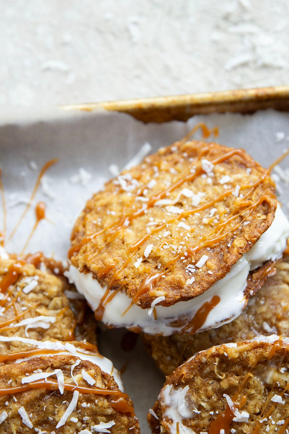 A base of crispy coconut cookies, homemade salted caramel, and a filling of creamy vanilla ice cream take these caramel ice cream sandwiches completely over the top!