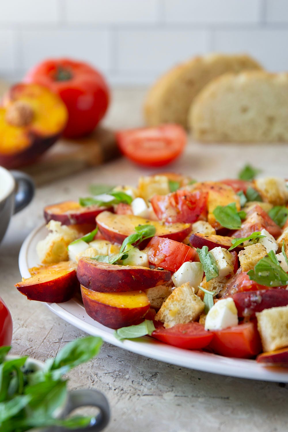 This summery peach panzanella salad is loaded down with crisp toasted bread, juicy peach slices, sweet tomatoes, and lots of fresh basil. A flavorful shallot dressing drizzled on top adds so much flavor!
