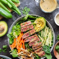 This seared ahi tuna salad features perfectly seared ahi tuna dressed up in bowls with lots of fresh greens, crunchy wonton strips, and a savory ginger soy dressing.