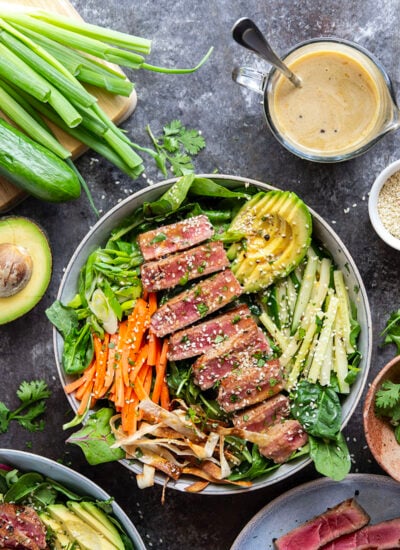 This seared ahi tuna salad features perfectly seared ahi tuna dressed up in bowls with lots of fresh greens, crunchy wonton strips, and a savory ginger soy dressing.