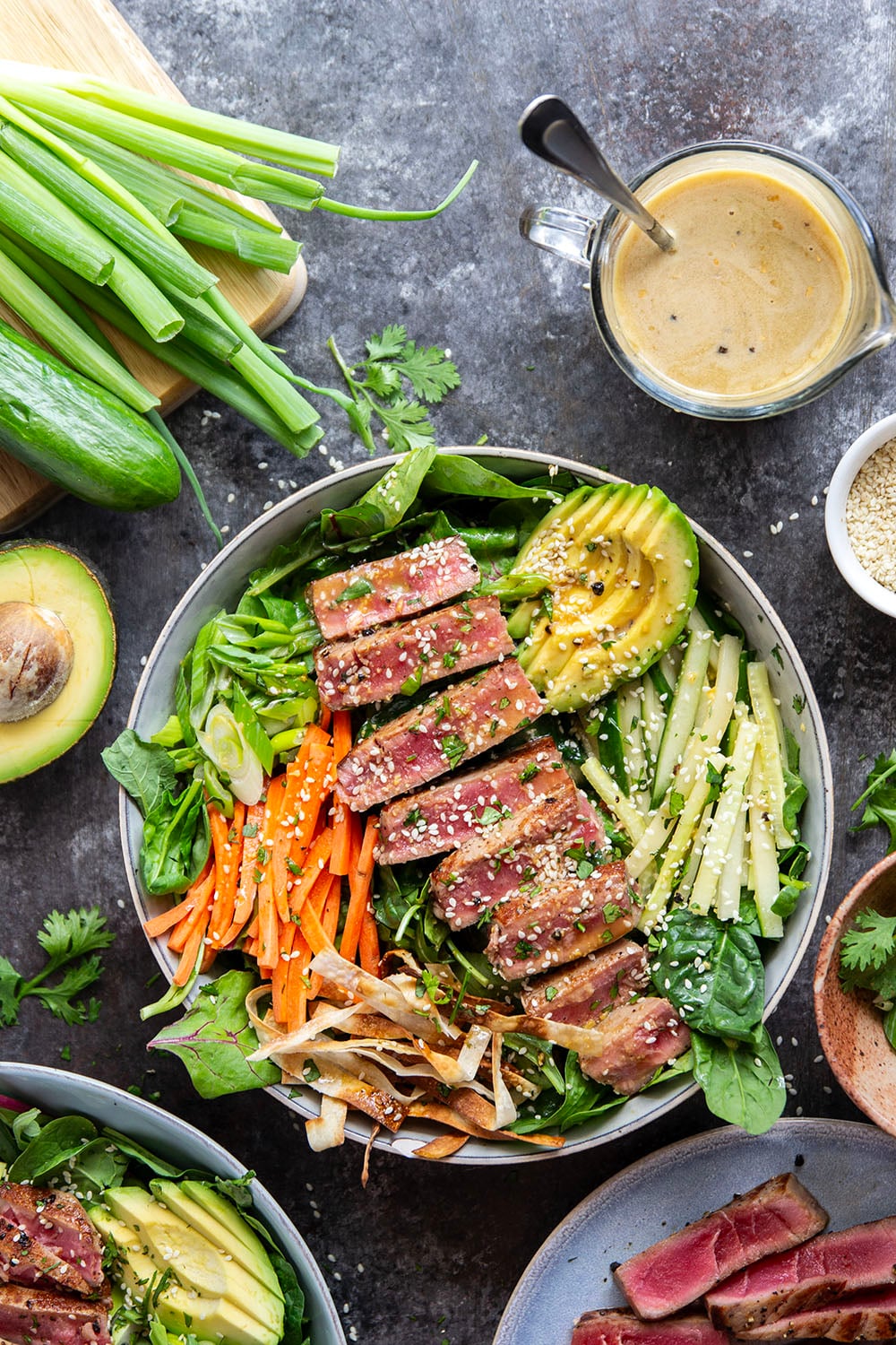 This seared ahi tuna salad features perfectly seared ahi tuna dressed up in bowls with lots of fresh greens, crunchy wonton strips, and a savory ginger soy dressing.