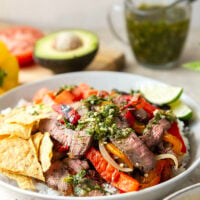 Juicy grilled sirloin steak, sweet peppers, and an herby fresh chimichurri sauce make for the ultimate summer steak fajita bowls.