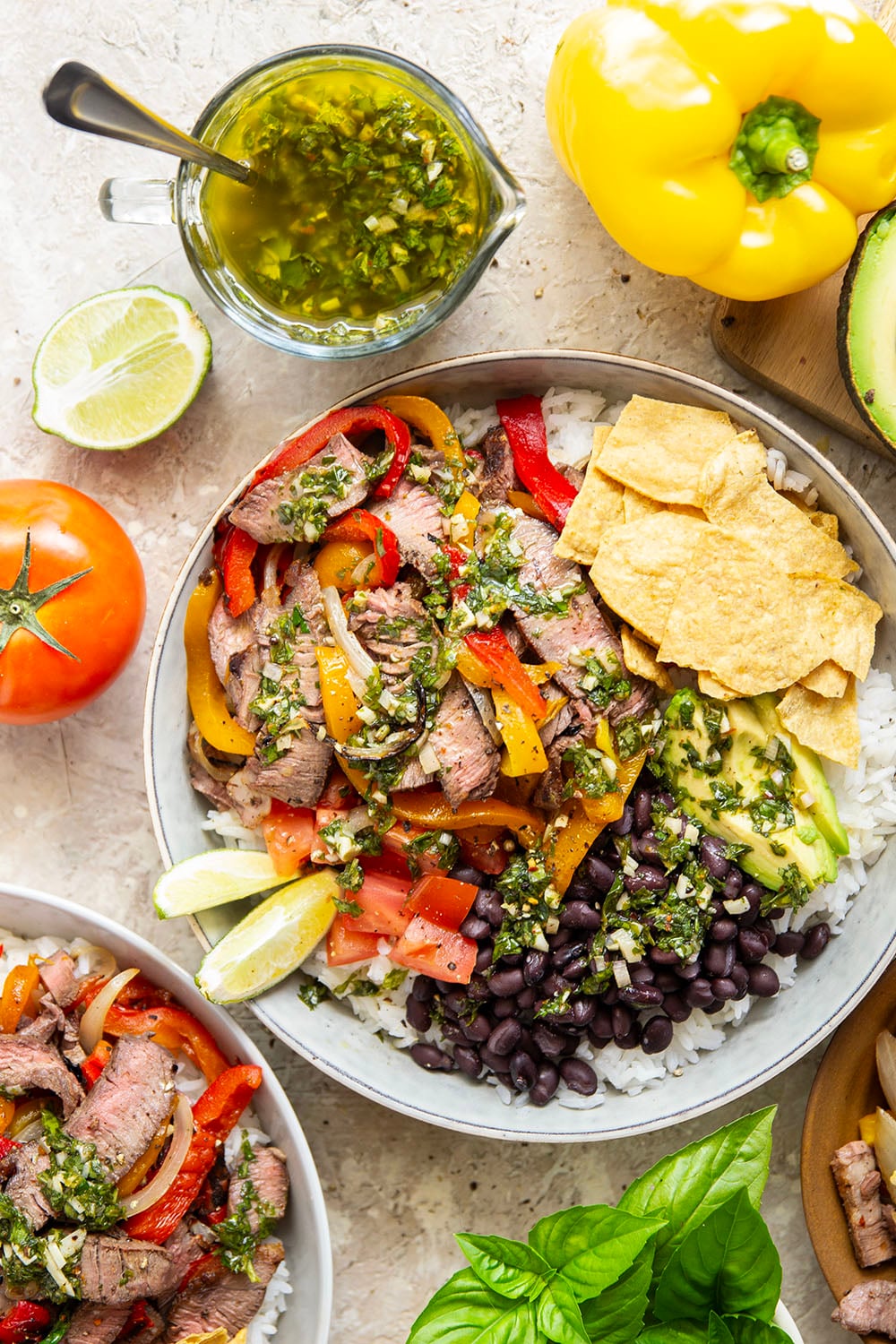 Juicy grilled sirloin steak, sweet peppers, and an herby fresh chimichurri sauce make for the ultimate summer steak fajita bowls.