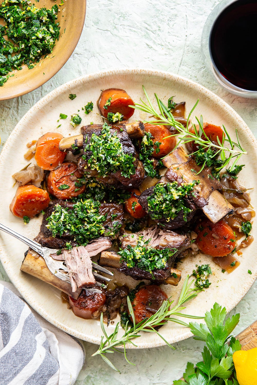 Fall-apart tender beef short ribs with gremolata feature red wine-braised short ribs cooked for hours until tender and topped with a fresh, herby gremolata topping.