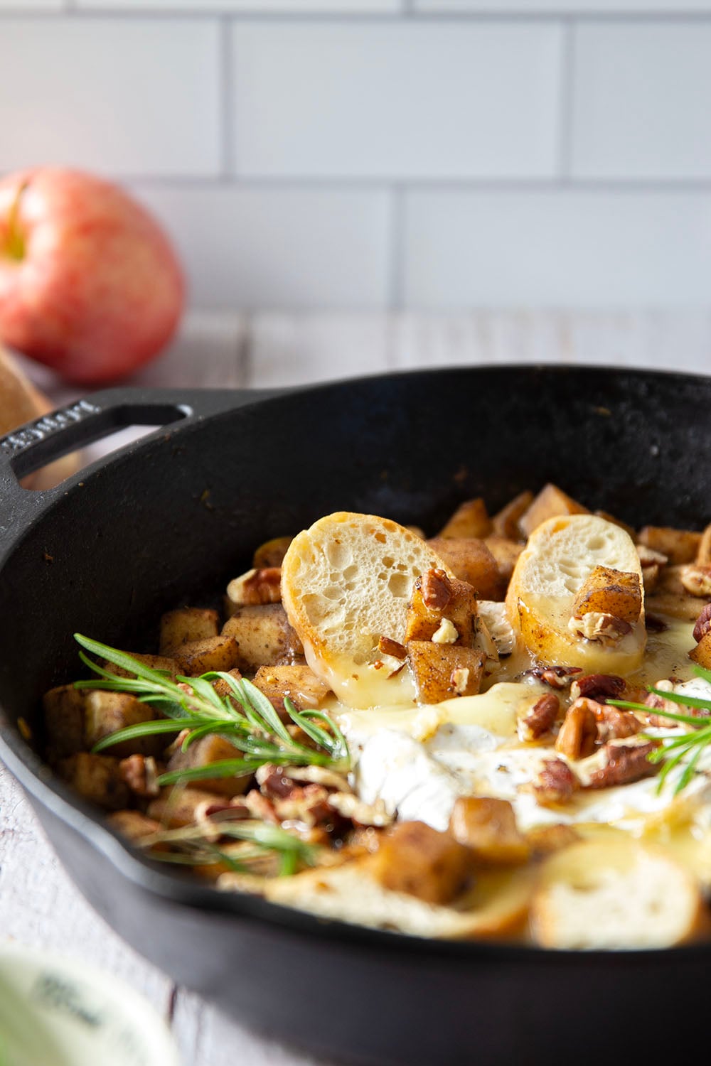 Honey-roasted apples and gooey brie make for the dream team in this honey apple baked brie that's always a hit appetizer with crostini for dipping.
