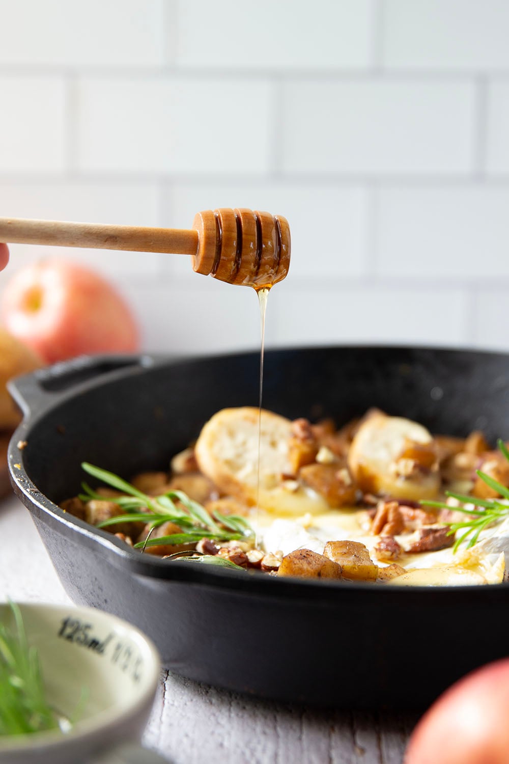Honey-roasted apples and gooey brie make for the dream team in this honey apple baked brie that's always a hit appetizer with crostini for dipping.