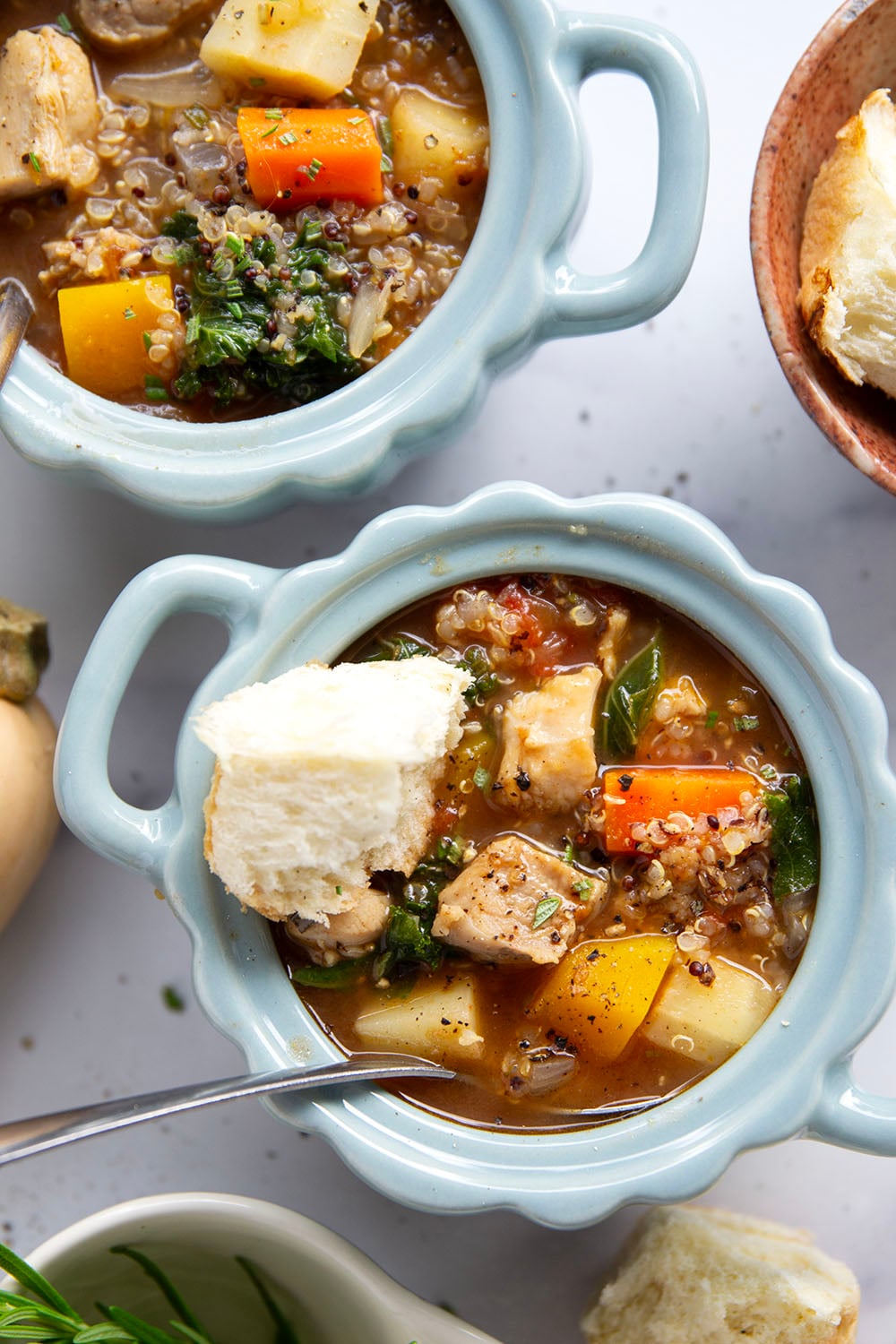 Warm and cozy bowls of quinoa chicken soup feature fall vegetables, lots of fluffy quinoa, and tender chicken cubes in a rich, flavorful broth.