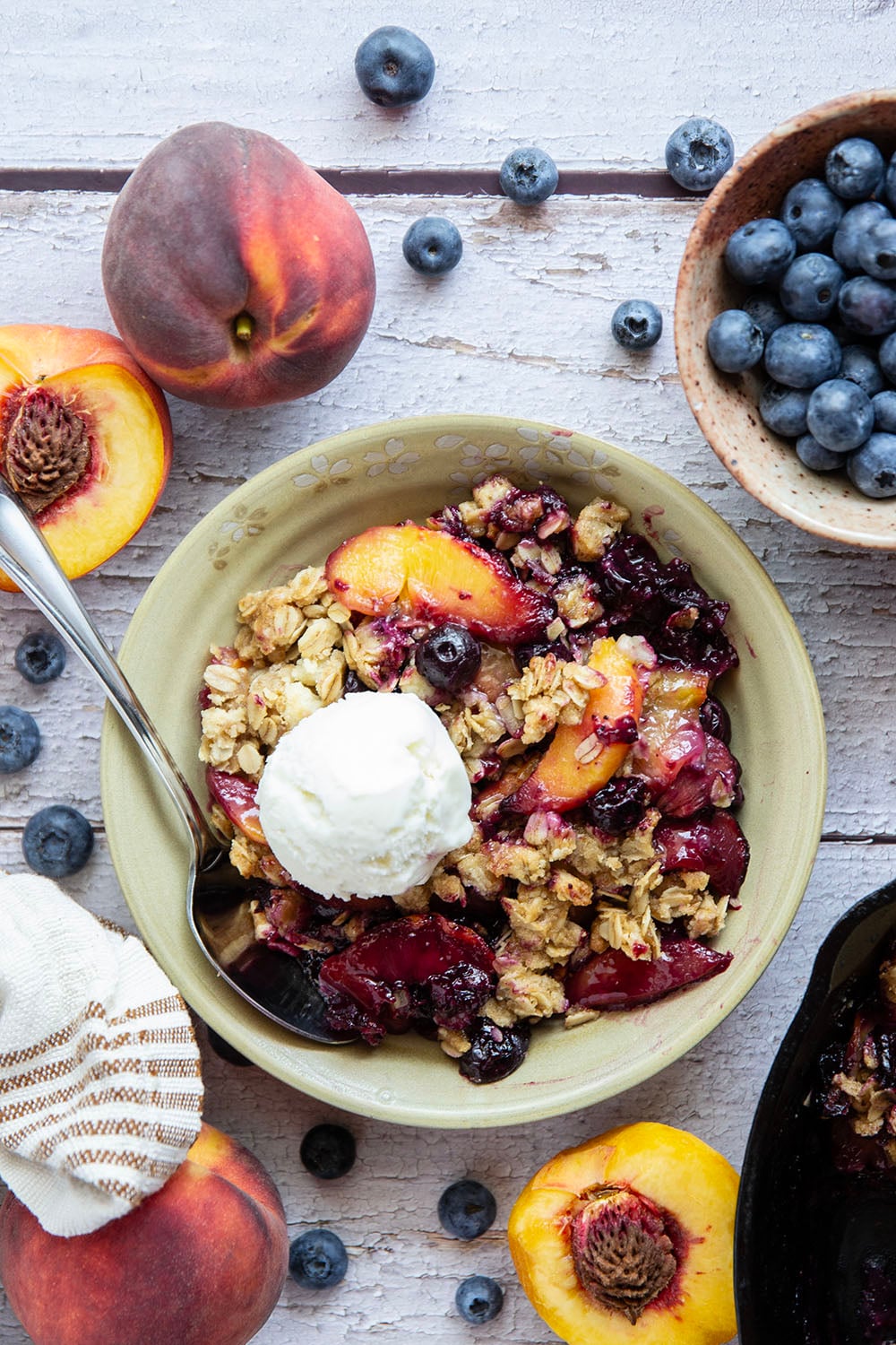 This peach blueberry crisp is all of summer's finest in one pan! Juicy peaches and blueberries, a crispy oatmeal streusel on top, and that obligatory scoop of vanilla ice cream.