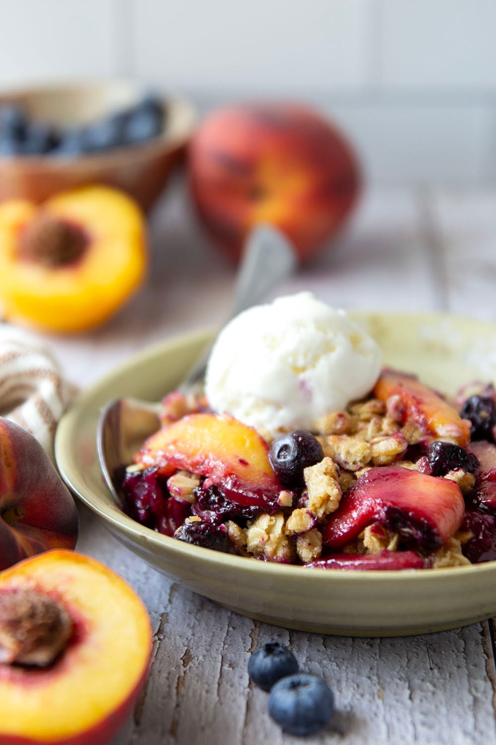 This peach blueberry crisp is all of summer's finest in one pan! Juicy peaches and blueberries, a crispy oatmeal streusel on top, and that obligatory scoop of vanilla ice cream.