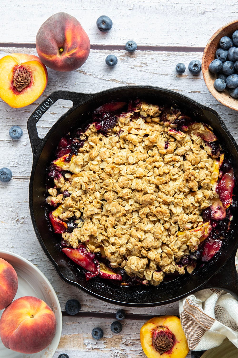 This peach blueberry crisp is all of summer's finest in one pan! Juicy peaches and blueberries, a crispy oatmeal streusel on top, and that obligatory scoop of vanilla ice cream.