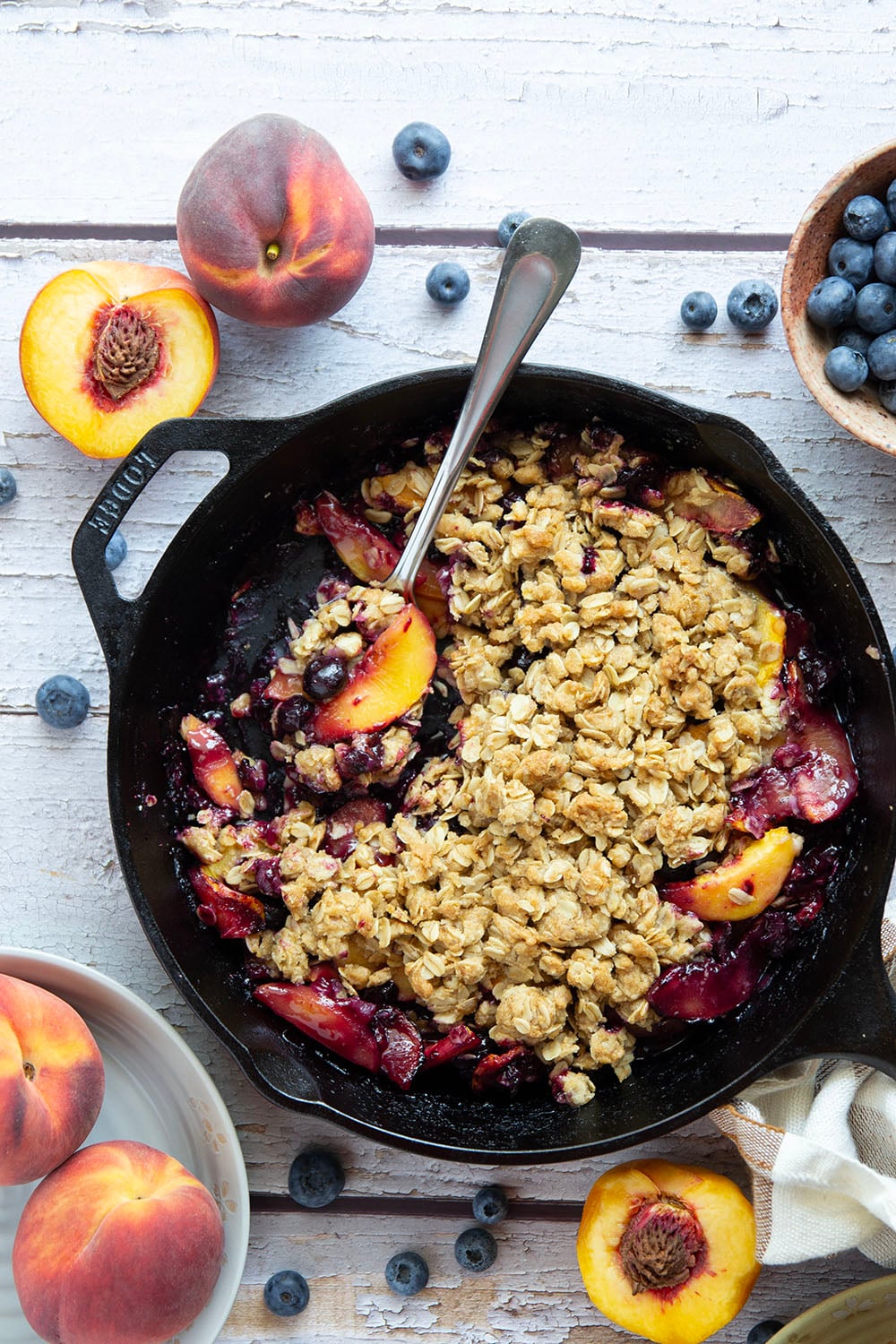 This peach blueberry crisp is all of summer's finest in one pan! Juicy peaches and blueberries, a crispy oatmeal streusel on top, and that obligatory scoop of vanilla ice cream.