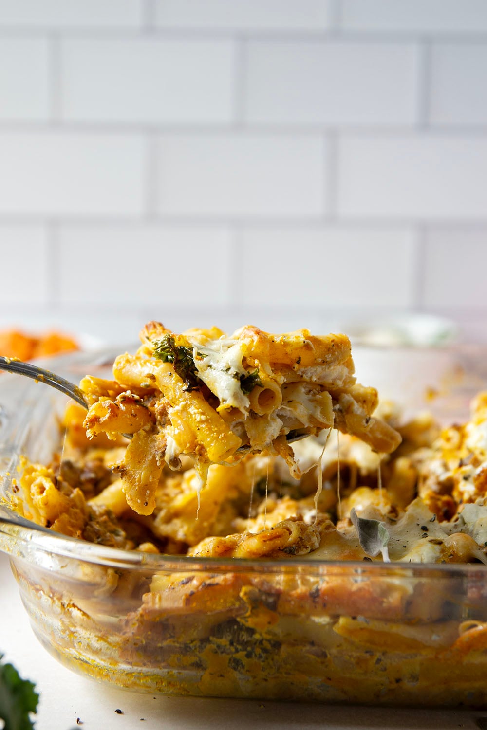 Baked in a creamy pumpkin white sauce with two kinds of cheese and tender sausage bits, this pumpkin baked ziti is a fun fall twist on the classic comfort dish.