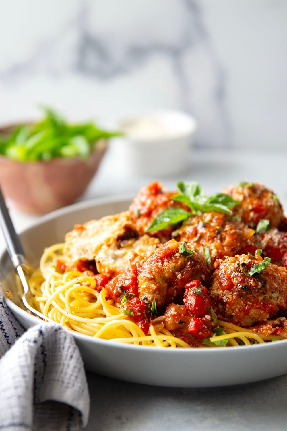 Moist and tender chicken ricotta meatballs are simmered in a flavorful roasted red pepper tomato sauce and are amazing served over spaghetti with lots of Parmesan and basil on top.