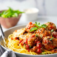Moist and tender chicken ricotta meatballs are simmered in a flavorful roasted red pepper tomato sauce and are amazing served over spaghetti with lots of Parmesan and basil on top.