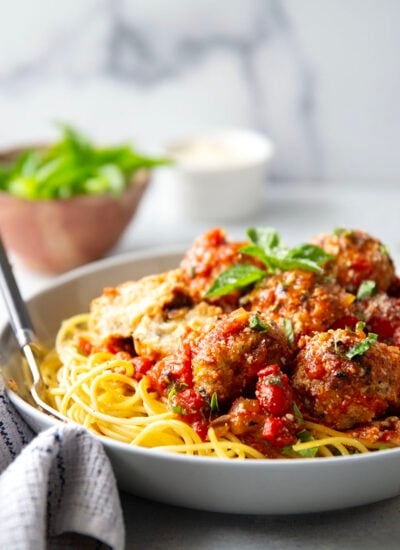 Moist and tender chicken ricotta meatballs are simmered in a flavorful roasted red pepper tomato sauce and are amazing served over spaghetti with lots of Parmesan and basil on top.