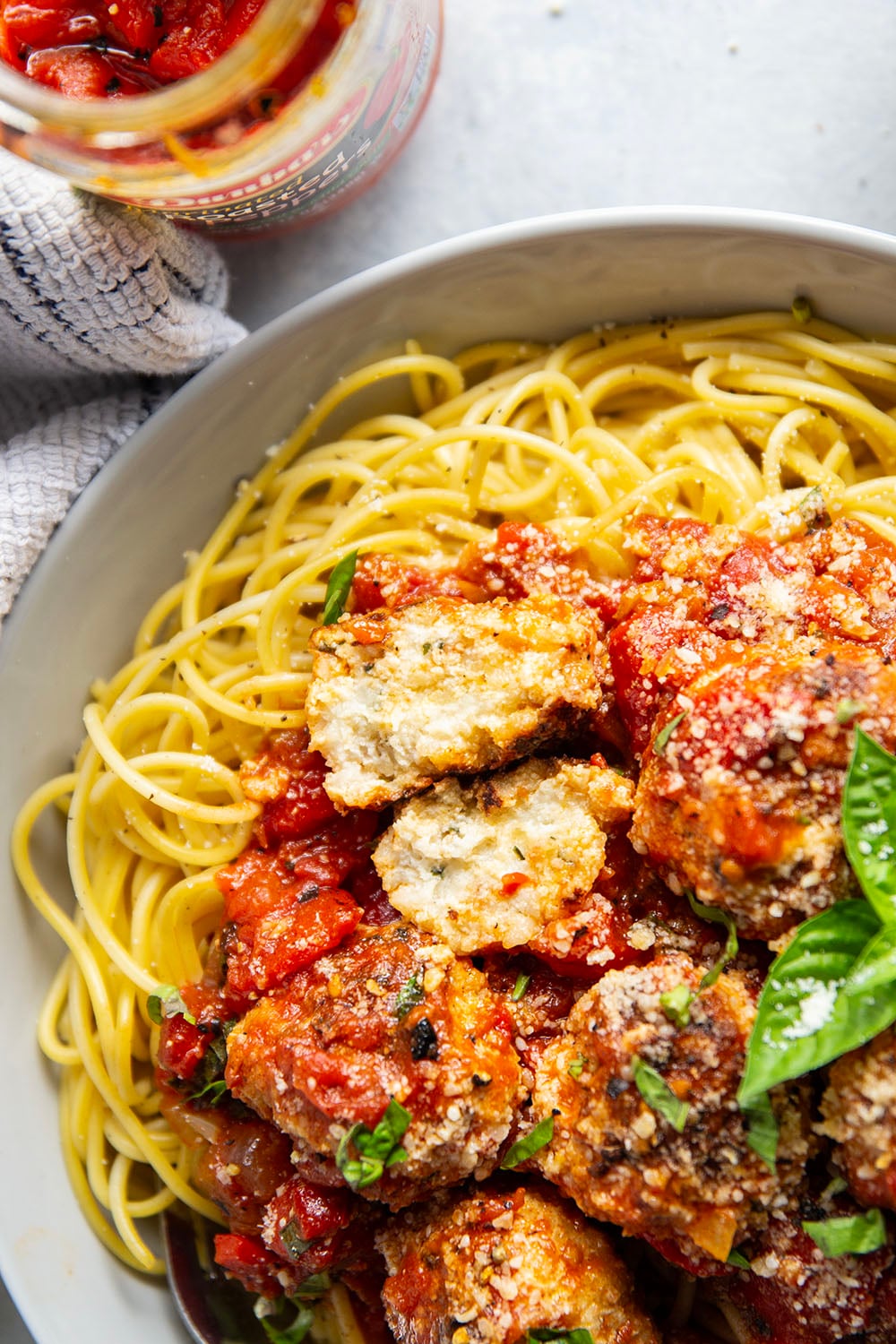 Moist and tender chicken ricotta meatballs are simmered in a flavorful roasted red pepper tomato sauce and are amazing served over spaghetti with lots of Parmesan and basil on top.