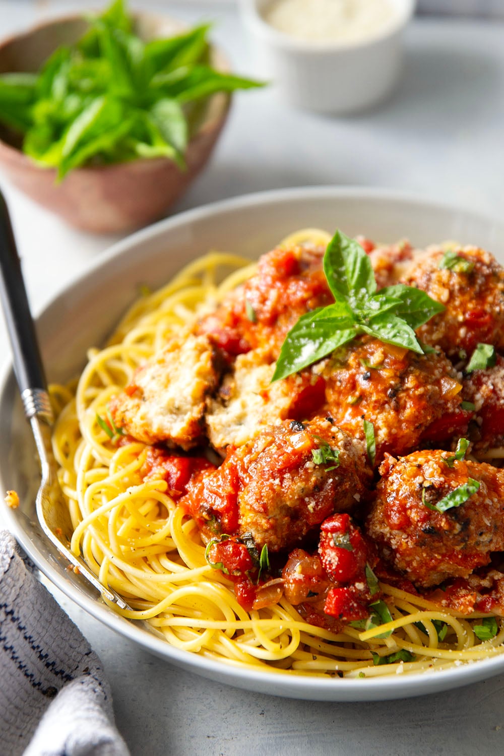 Moist and tender chicken ricotta meatballs are simmered in a flavorful roasted red pepper tomato sauce and are amazing served over spaghetti with lots of Parmesan and basil on top.