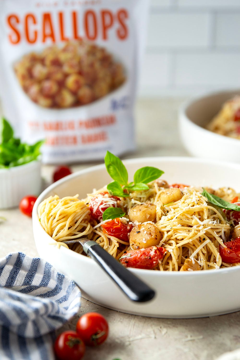 Garlicky scallops, bursting tomatoes, and lots of fresh Parmesan cheese star in this garlic Parmesan scallop pasta that comes together in minutes for an elevated weeknight meal.
