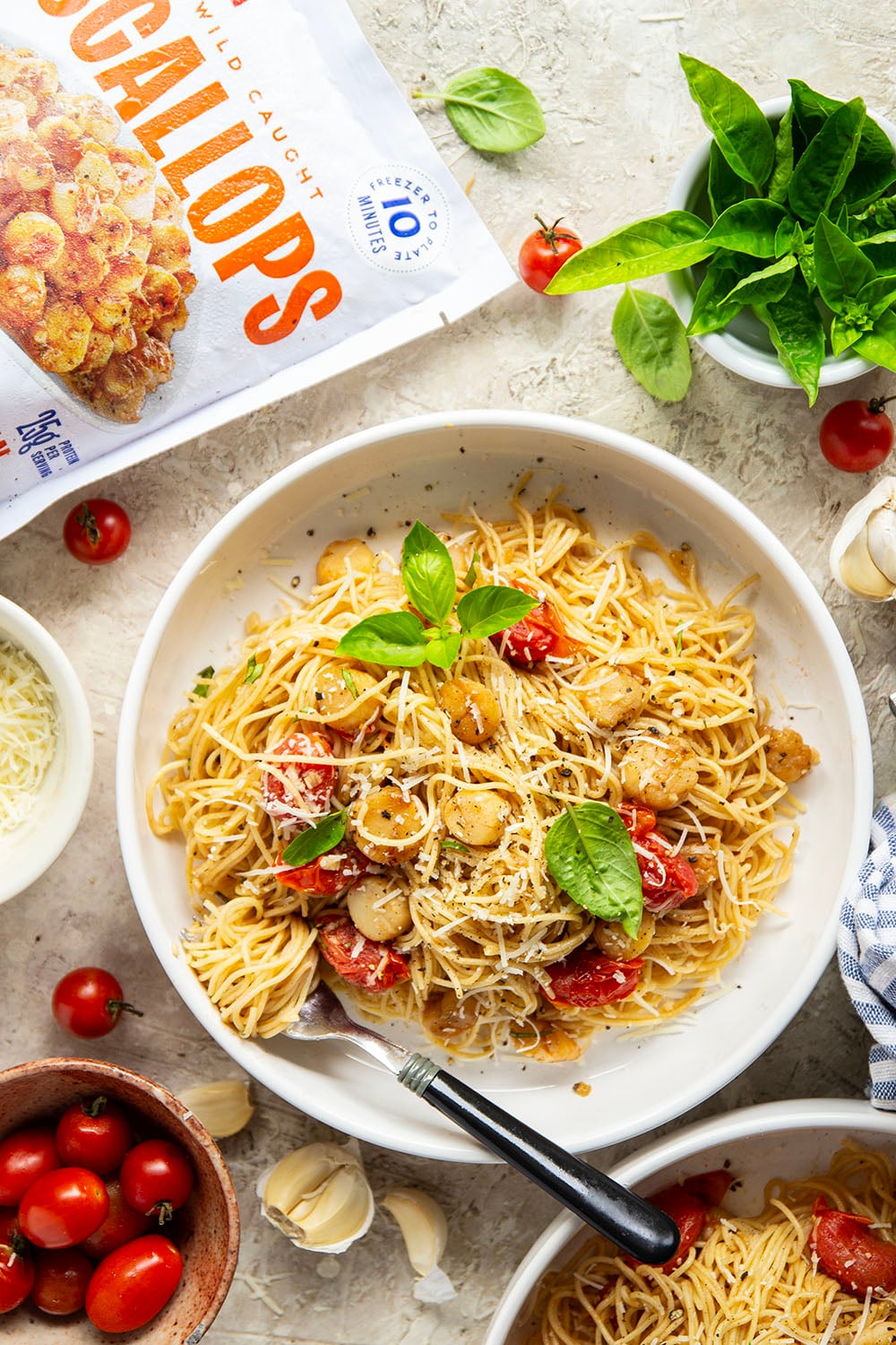 Garlicky scallops, bursting tomatoes, and lots of fresh Parmesan cheese star in this garlic Parmesan scallop pasta that comes together in minutes for an elevated weeknight meal.